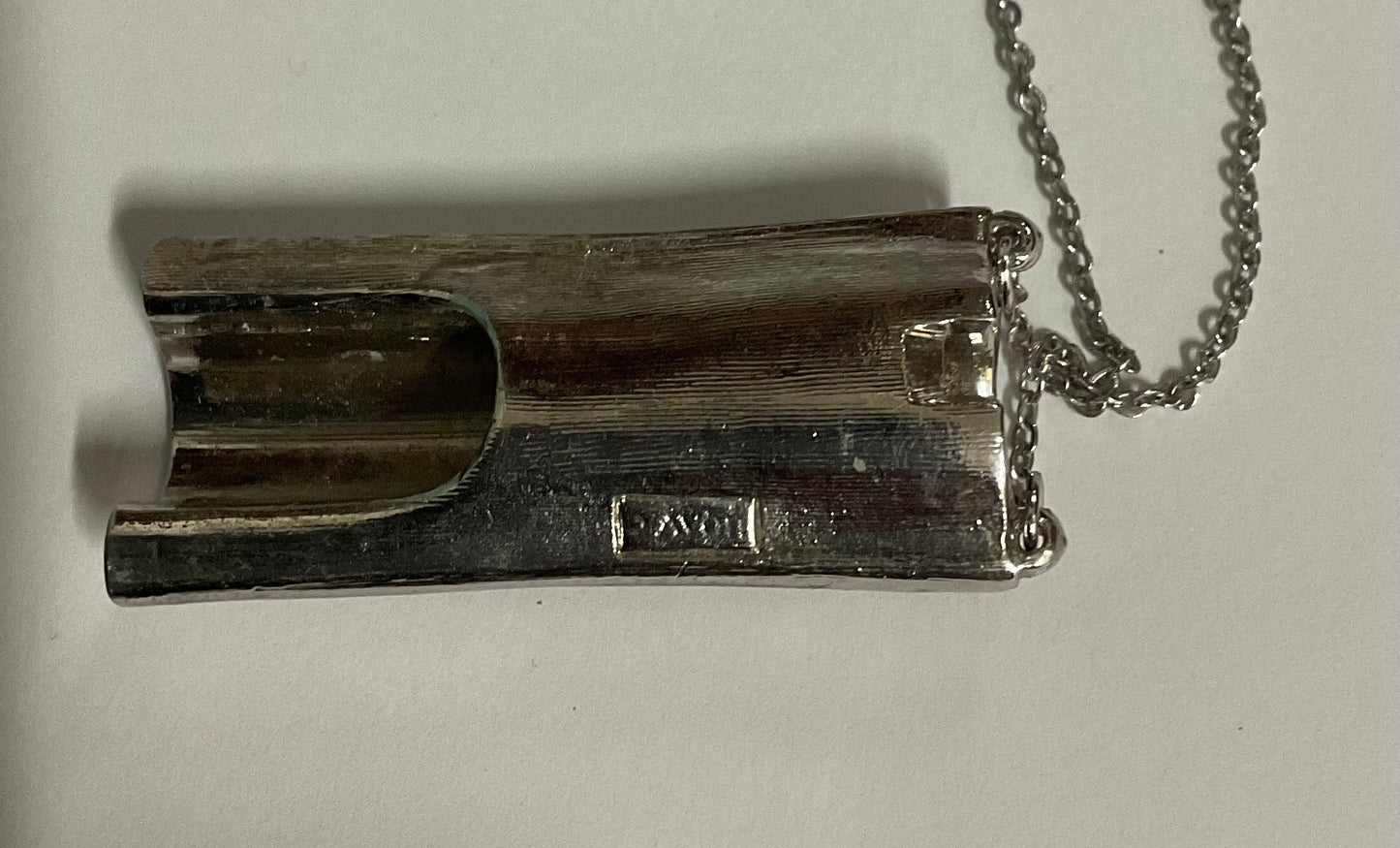 Vintage AVON modernist silver-tone pendant necklace featuring a sculptural tubular pendant with a reflective, wave-like design