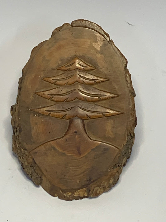 Hand Carved Wood Slice featuring a detailed evergreen tree design carved in relief