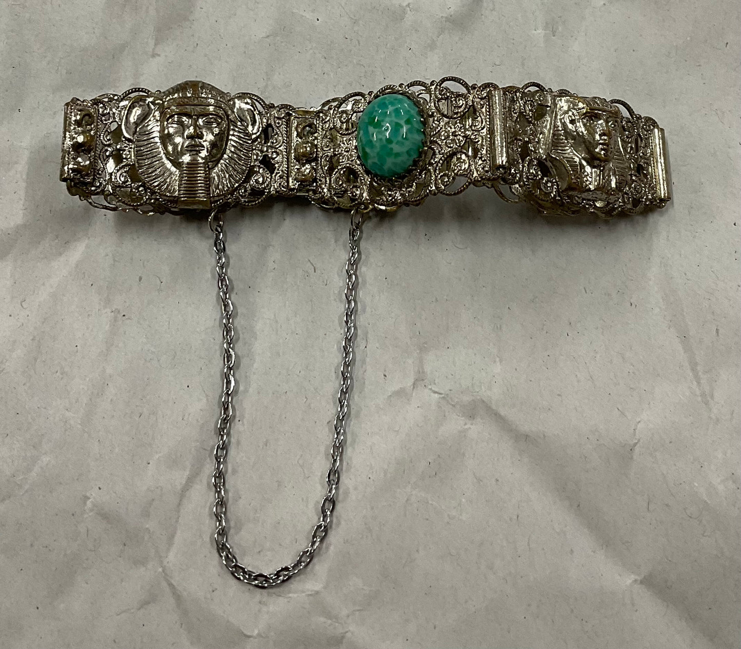 Vintage Egyptian Revival silver-tone filigree bracelet, featuring ornate Pharaoh and Sphinx motifs with raised relief detail