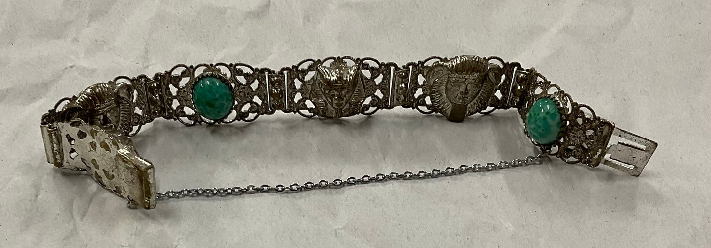 Vintage Egyptian Revival silver-tone filigree bracelet, featuring ornate Pharaoh and Sphinx motifs with raised relief detail