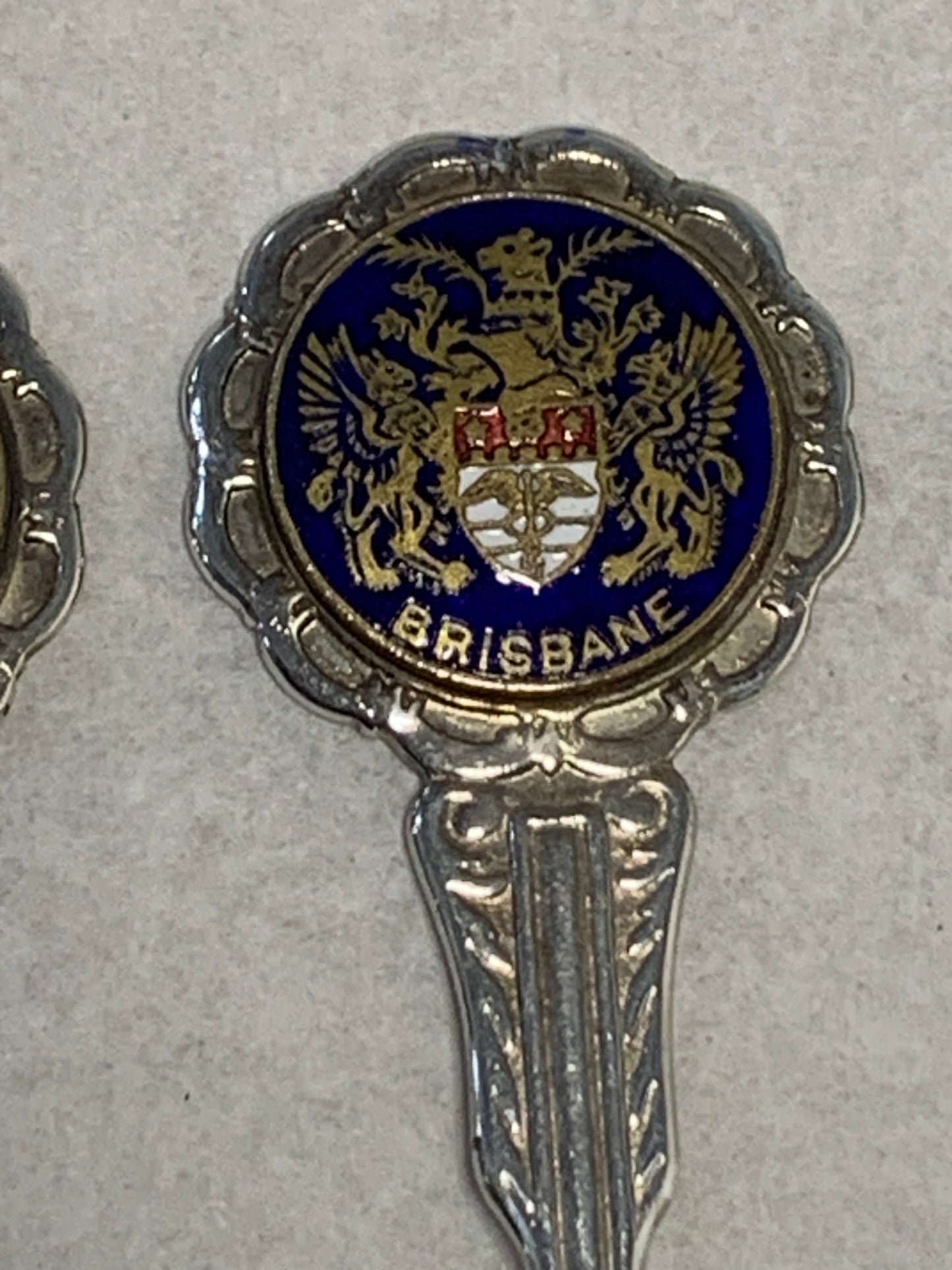 Set of six vintage silver-plated souvenir teaspoons featuring the enameled coats of arms of Australia’s state capital cities: Adelaide, Brisbane, Sydney, Perth, Hobart, and Melbourne