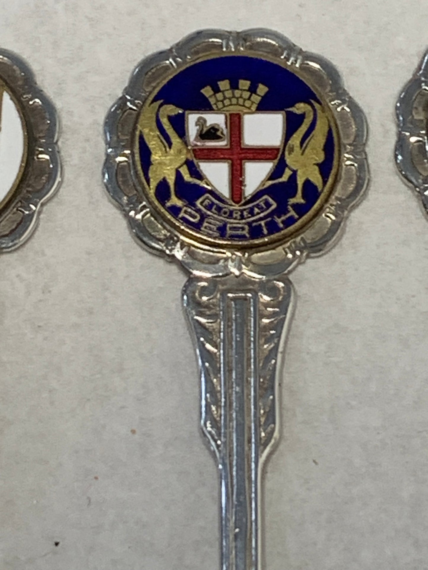 Set of six vintage silver-plated souvenir teaspoons featuring the enameled coats of arms of Australia’s state capital cities: Adelaide, Brisbane, Sydney, Perth, Hobart, and Melbourne
