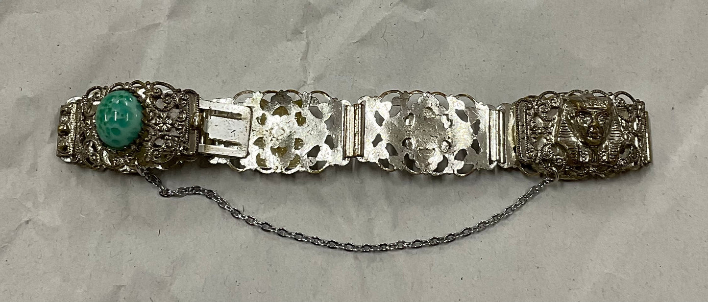 Vintage Egyptian Revival silver-tone filigree bracelet, featuring ornate Pharaoh and Sphinx motifs with raised relief detail
