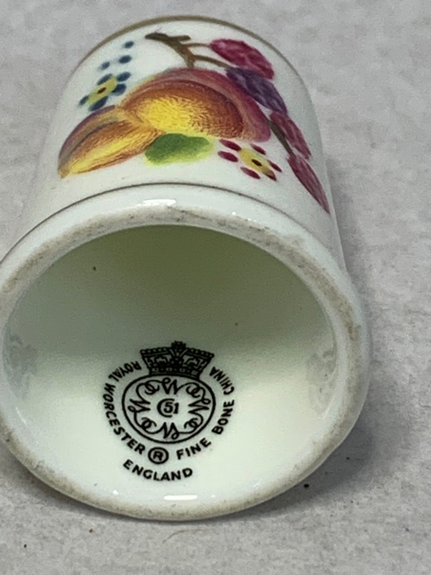 Pair of Royal Worcester fine bone china thimbles, hand-painted with fruit still-life designs (plums, cherries, apricots, and berries) on a white ground with gilt rims 1951