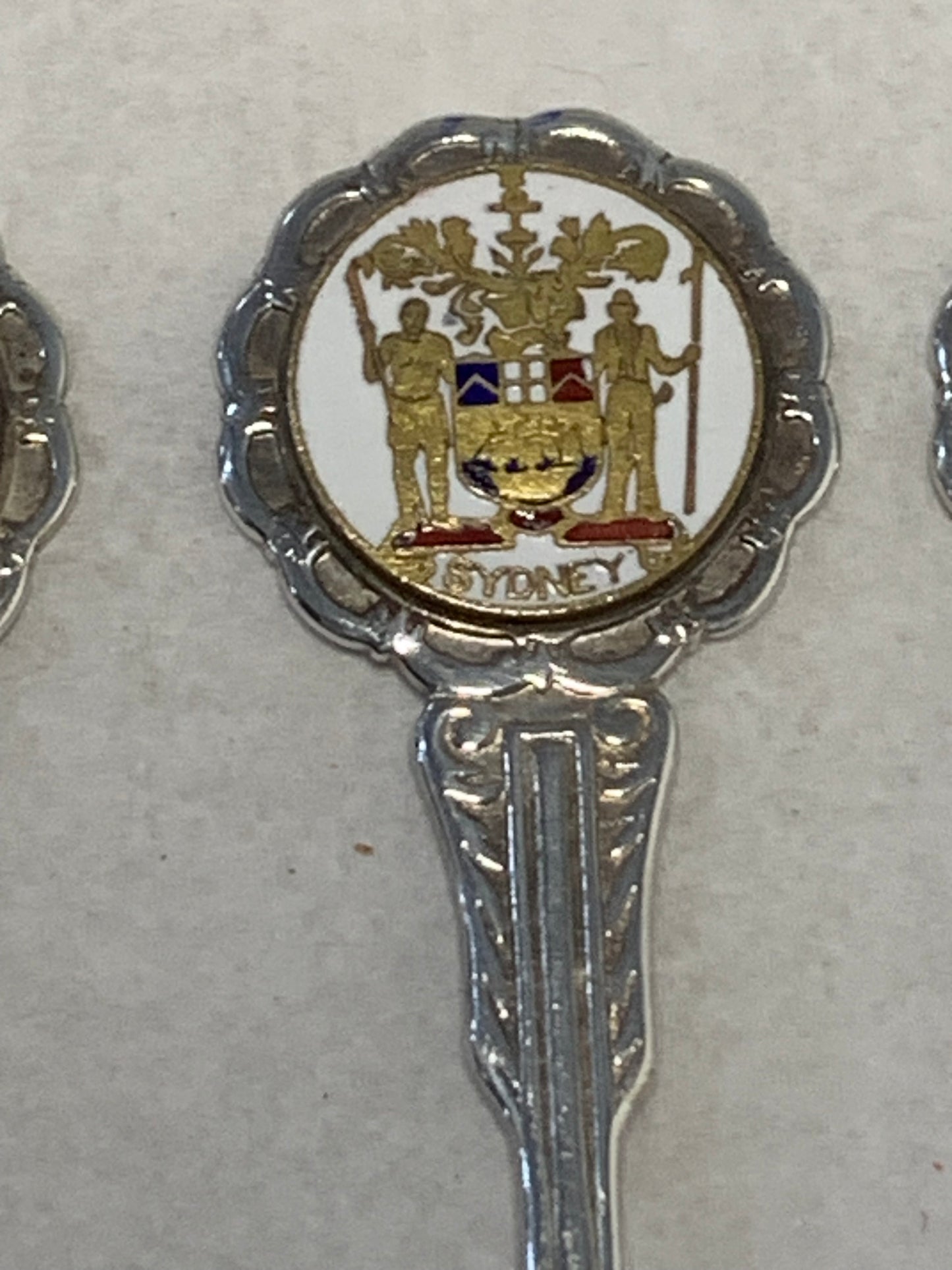 Set of six vintage silver-plated souvenir teaspoons featuring the enameled coats of arms of Australia’s state capital cities: Adelaide, Brisbane, Sydney, Perth, Hobart, and Melbourne