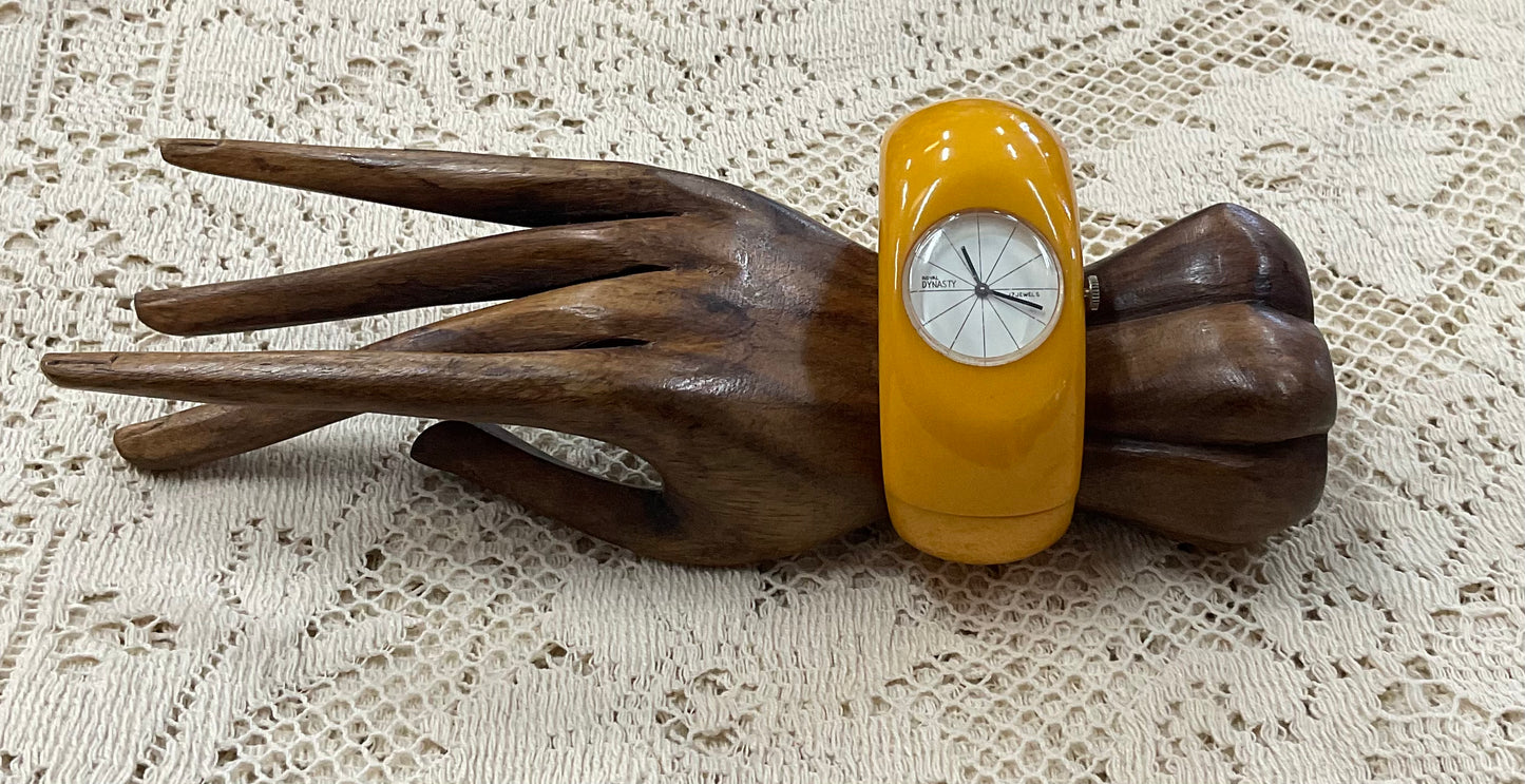 Vintage Royal Dynasty Bakelite butterscotch yellow cuff bangle watch featuring a bold mid-century modern design